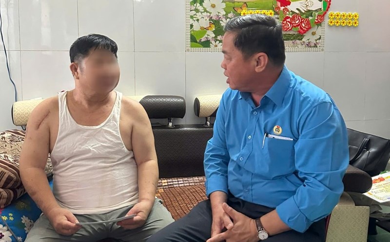 Mr. Nguyen Ba Hung (right) visited and encouraged the union member who was in an accident and was being treated at home. Photo: Ngoc Cam