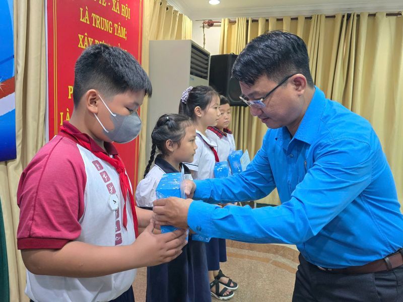 Mr. Tran Van Thanh Hung - Chairman of the District 4 Labor Federation - presented Nguyen Duc Canh scholarship to primary school students. Photo: Nam Duong