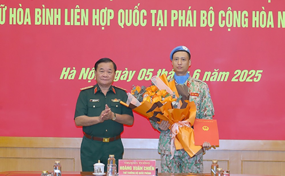 Thuong tuong Hoang Xuan Chien - Thu truong Bo Quoc phong trao quyet dinh va tang hoa chuc mung Thieu ta Tran Viet Cuong. Anh: Bo Quoc phong  