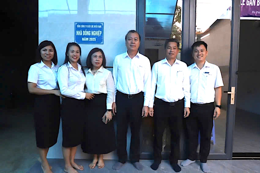 A representative of Binh Phuoc Power Company congratulated union member Bui Thi Hanh on her new solid house. Photo: Le Thuy