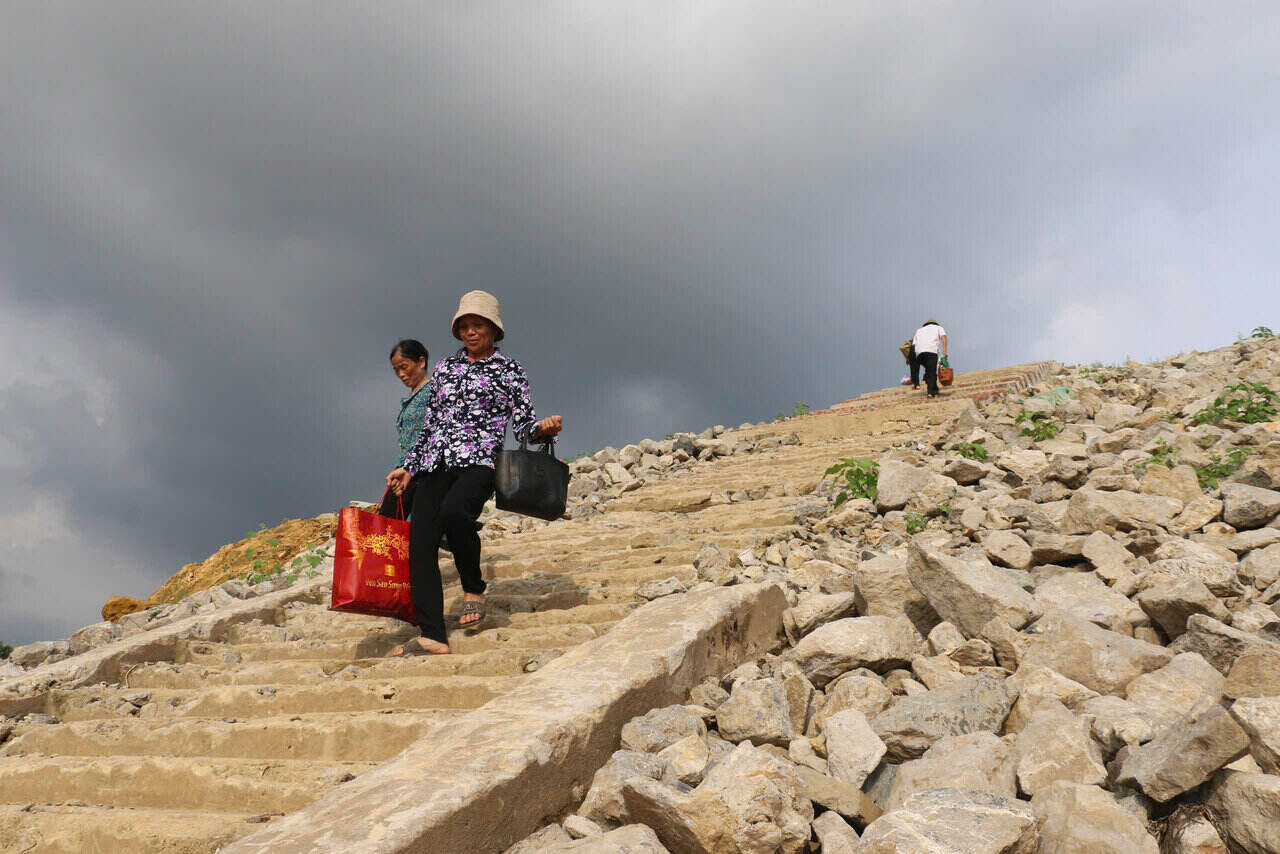 Nguoi dan tat ta bang qua nhung bac thang da tro troi giua long ho Hoa Binh kho can. Noi tung ngap sau trong nuoc nay de lo nen da go ghe, tro thanh hanh trinh thuong nhat day vat va cua ba con vung long ho.