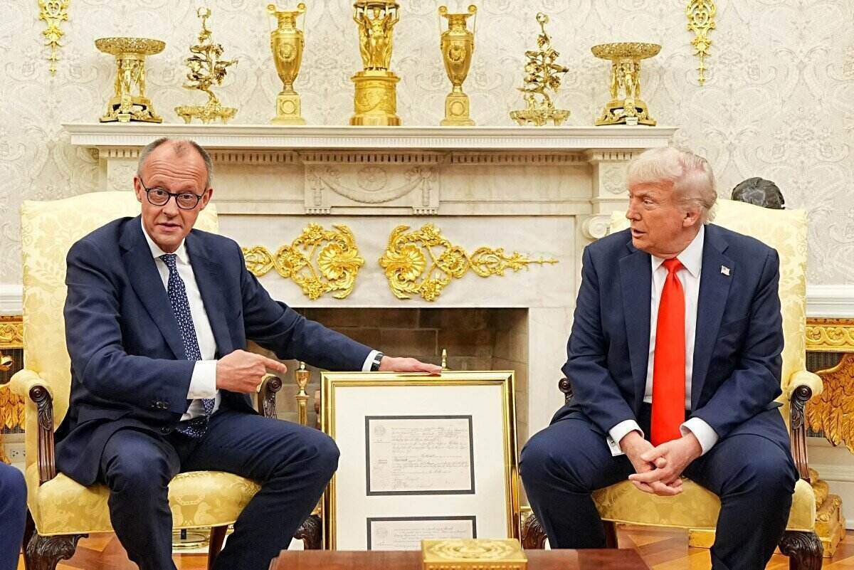 El primer ministro aleman, Friedrich Merz, le presento al presidente estadounidense Donald Trump una copia del certificado de nacimiento de su abuelo. Foto: AFP