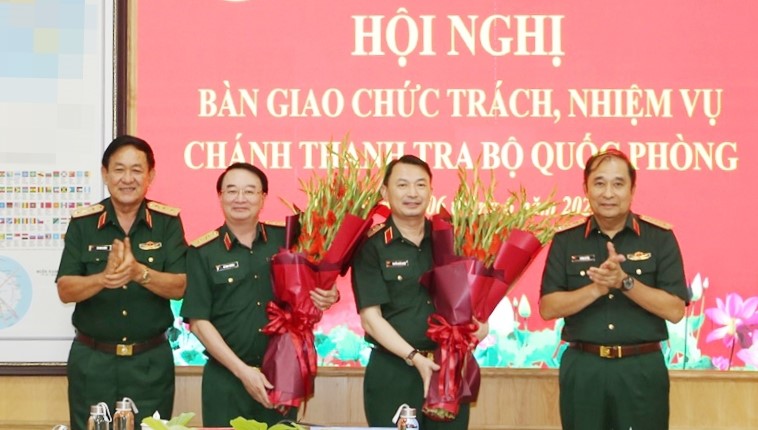 Delegates presented flowers to congratulate Lieutenant General Le Dinh Thuong (left) and Lieutenant General Nguyen Quoc Duyet for their handover of duties and responsibilities as Chief Inspector of the Ministry of National Defense. Photo: VGP