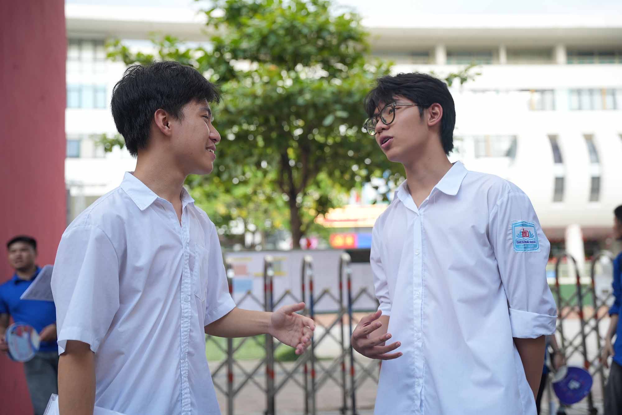 Hai thi sinh du thi tai Truong THCS My Dinh 1 hoi han nhau ve bai thi mon Tieng Anh. Anh: Huu Chanh