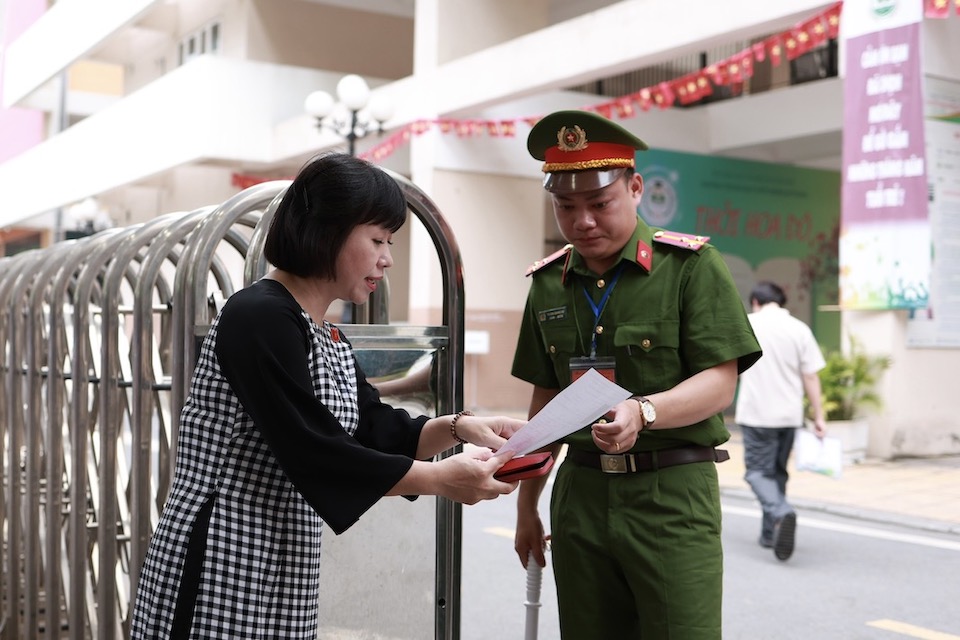 Bi thu doan trng My Dinh trao doi voi llcn dua do dung hoc tap cho thi sinh tai phong thi. Anh: Hai Nguyen 