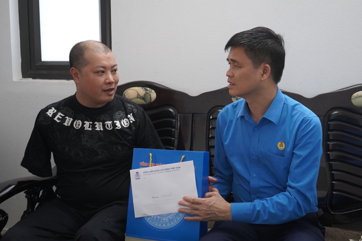 Vicepresidente de la Confederacion General de Trabajo de Vietnam, ONG Duy Hieu dando regalos a los miembros del sindicato. Foto: Mai Dung