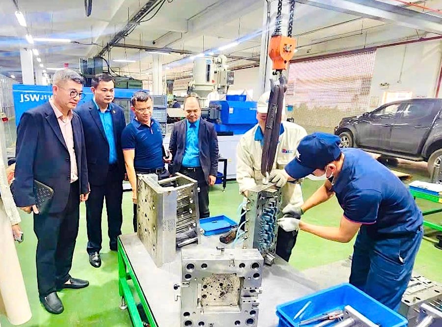 Sr. Nguyen Dinh Thang - Presidente del sindicato de Hanoi Industrial Zones & CX (2º desde la izquierda) para contactar con las empresas. Foto: HA ANH