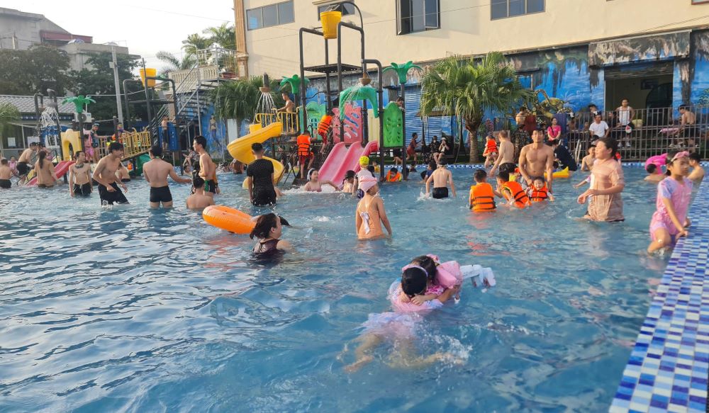 Children enjoy a cool summer's warm bath and learn swimming skills in Vu Thu district, Thai Binh province. Photo: Nam Hong
