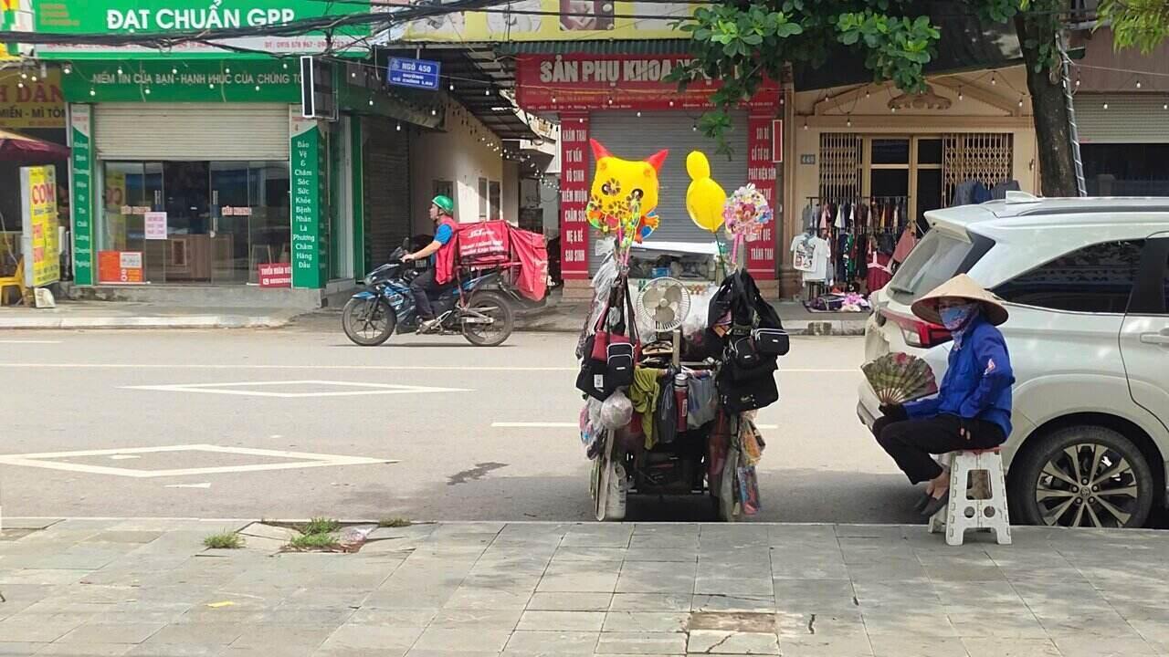 Giua cai nang gay gat, chi Huong (45 tuoi, que o An Thi, Hung Yen) van miet mai day chiec xe hang rong quen thuoc tren pho. Anh: Binh Khang.