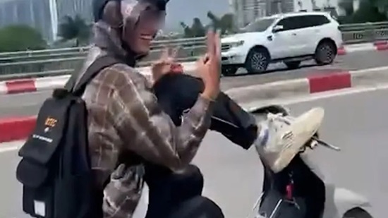 Hình ảnh nam thanh niên dùng chân điều khiển xe máy. Ảnh cắt từ clip