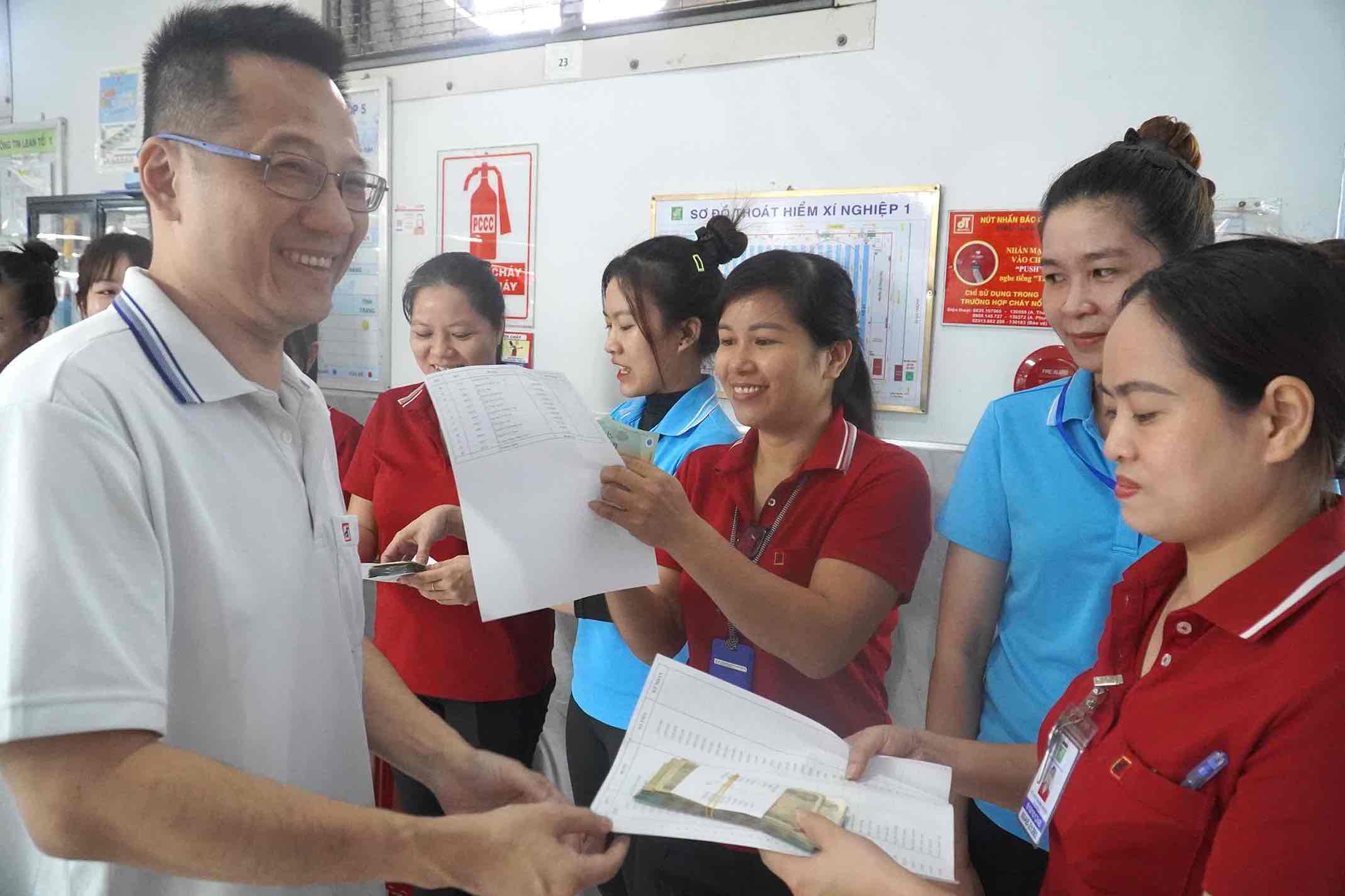 Chi thưởng cho người lao động công ty Cổ phần Đồng Tiến. Ảnh: HAC