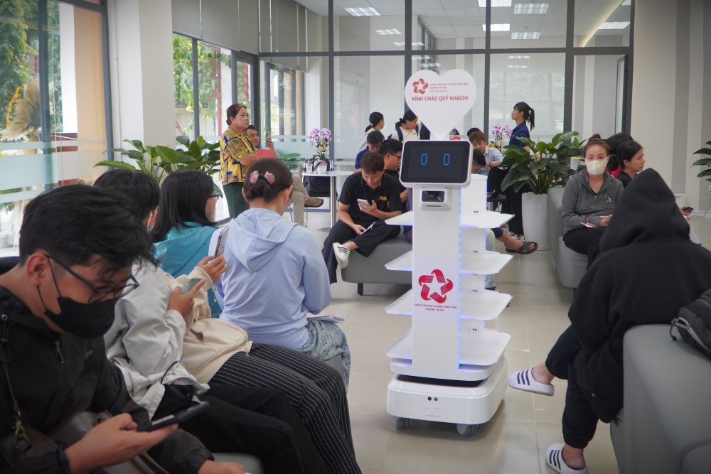 Robot di chuyen xung quanh khu vuc cho de tiep nhan ho so. Anh: Anh Tu