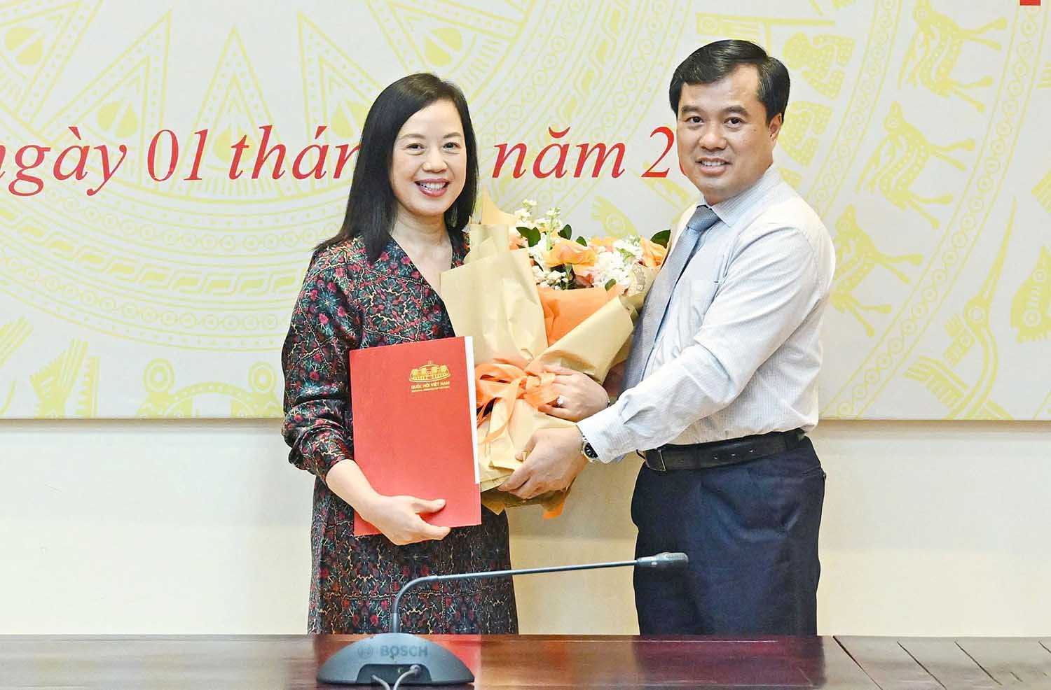 Deputy Head of the National Assembly Office Nguyen Manh Hung presented the decision to retire early to Ms. Pham Thi Bich Ngoc, Deputy Chief of the Office of the Party Committee of the National Assembly Office. Photo: T. Thanh.