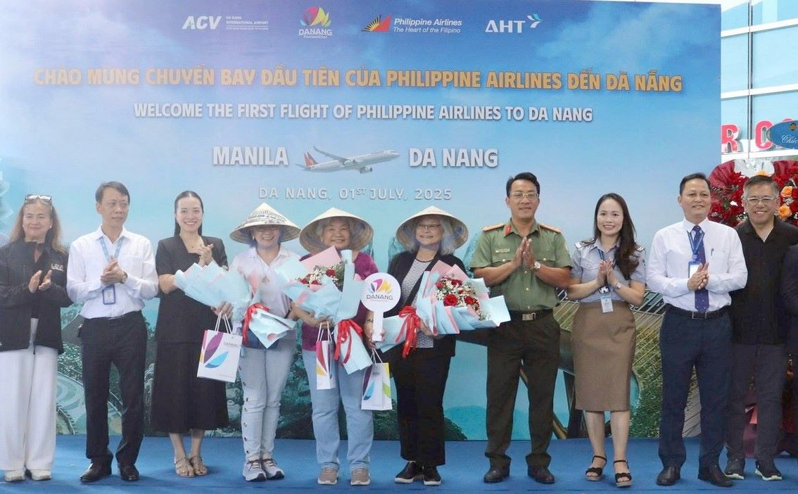 マニラからダナンへの最初のフライトで観光客に花やお土産を贈る。写真:An Thuong