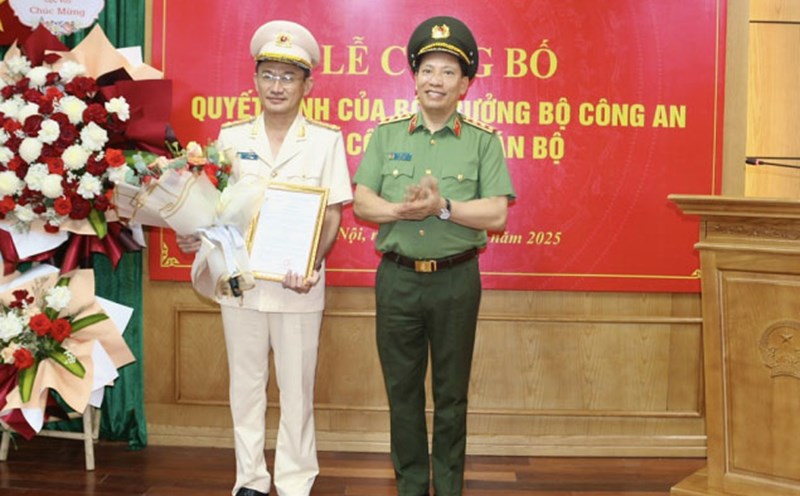 Deputy Minister of Public Security Le Van Tuyen (right) presented the transfer decision to Colonel Tran Van Duong. Photo: P. Tam