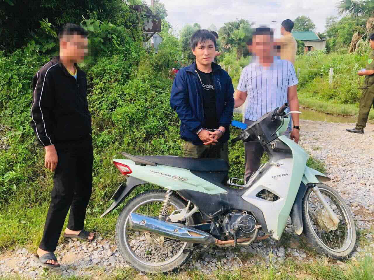 Doi tuong Nguyen Thanh Trung cung tang vat (o giua) thoi diem bi bat giu. Anh: Cong an Dong Le