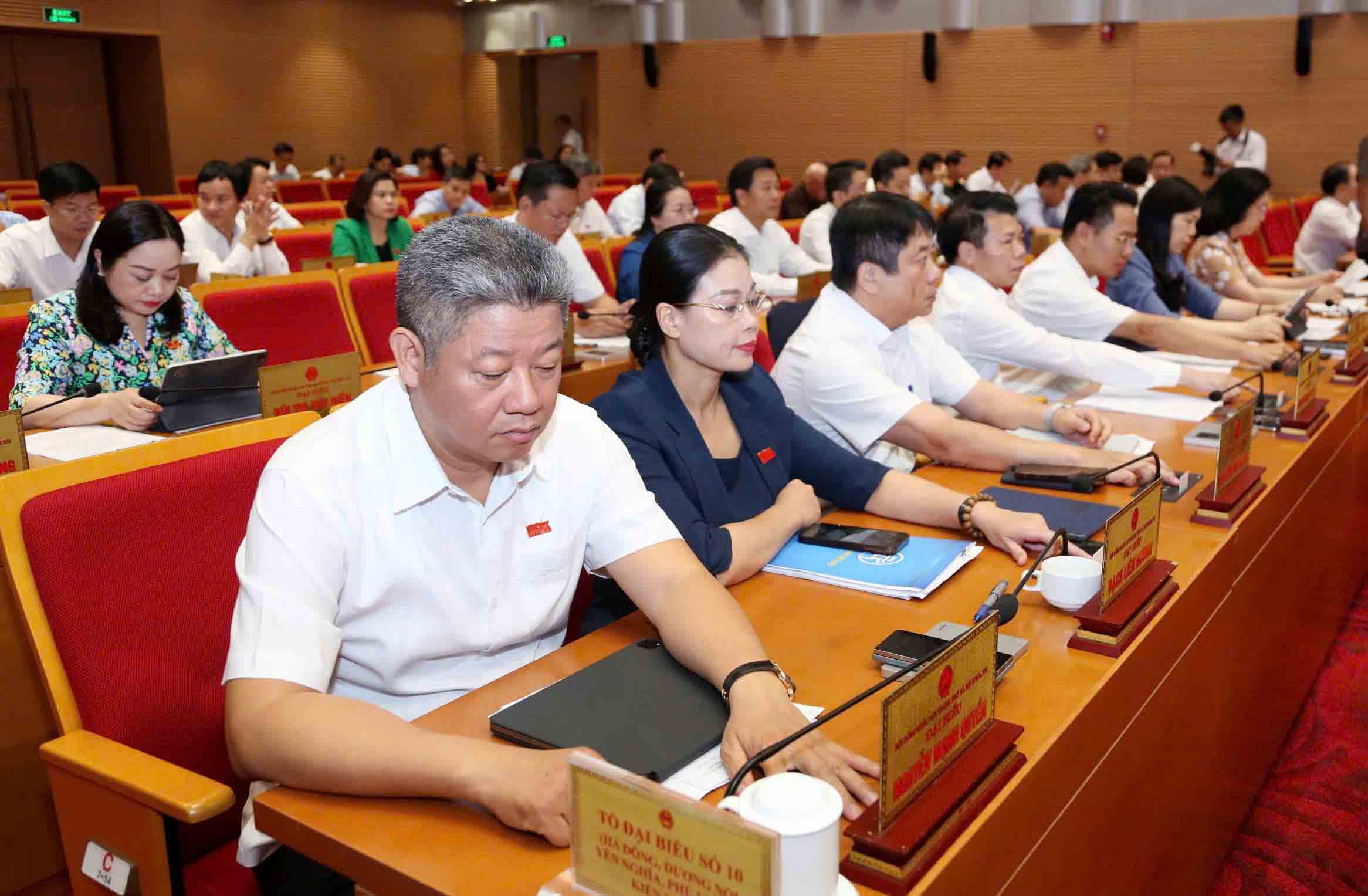 Hanoi People's Council delegates press the button to approve the Resolution. Photo: Quang Thai