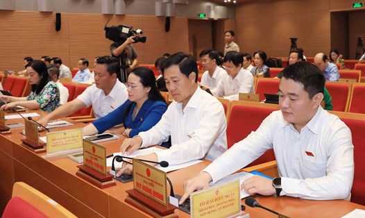 Các đại biểu ấn nút thông qua Nghị quyết quy định biện pháp giảm phát thải nhựa trên địa bàn thành phố Hà Nội, sáng 10.7. Ảnh: Quang Thái