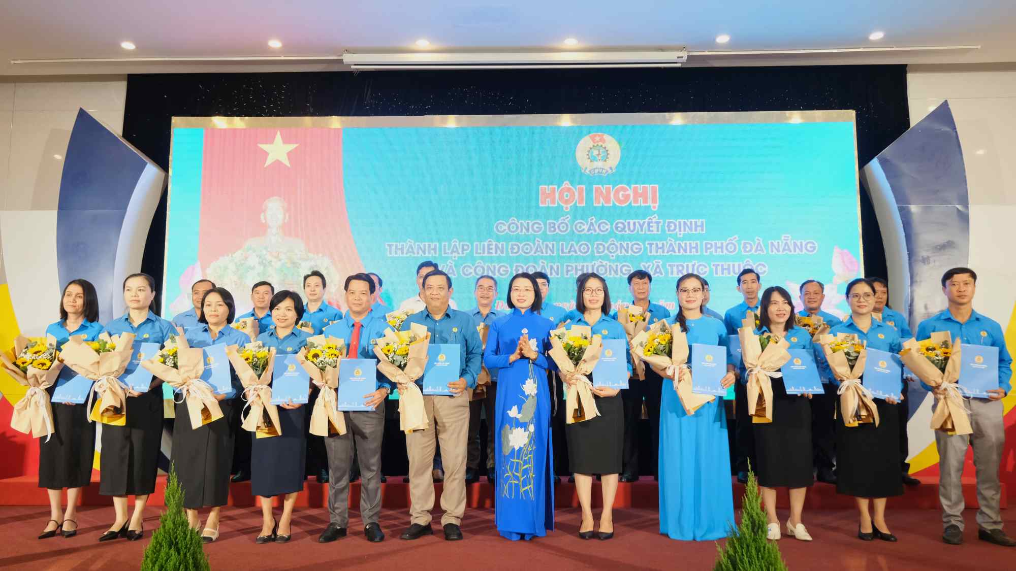 Sra. Phan Thi Thuy Linh - Presidenta de la Federacion Laboral Da Nang (Ao Dai, Middle) - Dio flores para felicitar a 24 sindicatos de comunas y salas. Foto: An Thuong