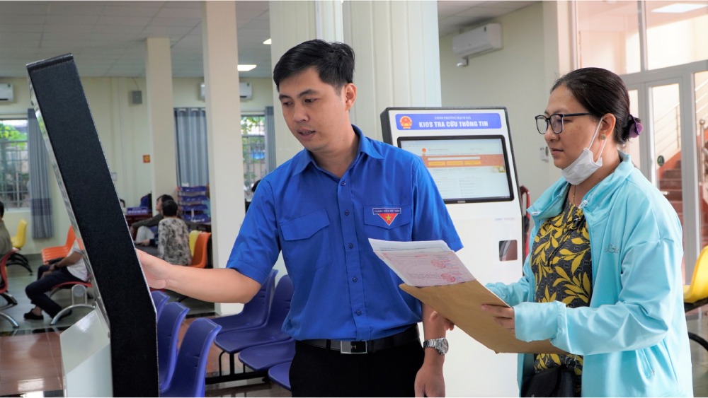 Can bo ho tro nguoi dan den lam thu tuc. Anh: Nguyen Anh