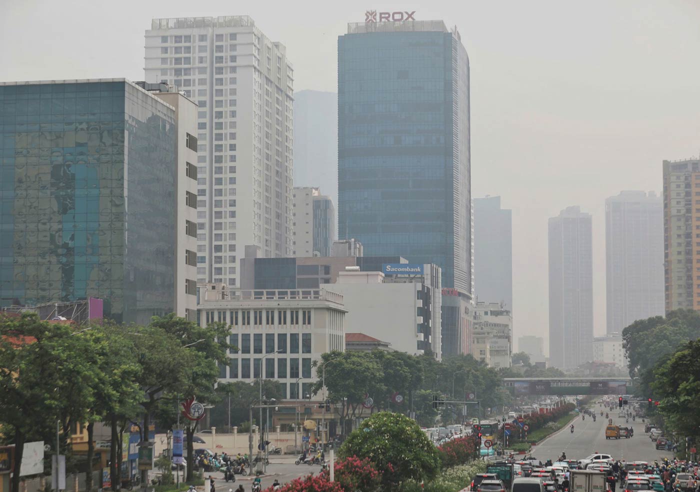 Ghi nhan den gan trua ngay 14.7, bau troi Ha Noi van mo duc, cac toa nha cao tang mo ao khi nhin tu xa.