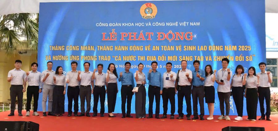 Dang Ngoc Sonさん(左隣)が2025年労働者月間を記念してベトナム科学技術労働組合から贈り物を受け取る。写真:Quynh Chi