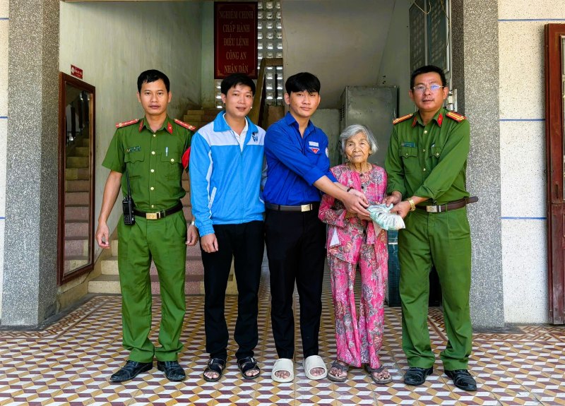 Em Thanh trao lai so tien nhat duoc cho cu Han truoc su chung kien cua Cong an, Doan Thanh nien xa Tien Phuoc, Da Nang. Anh: CACC