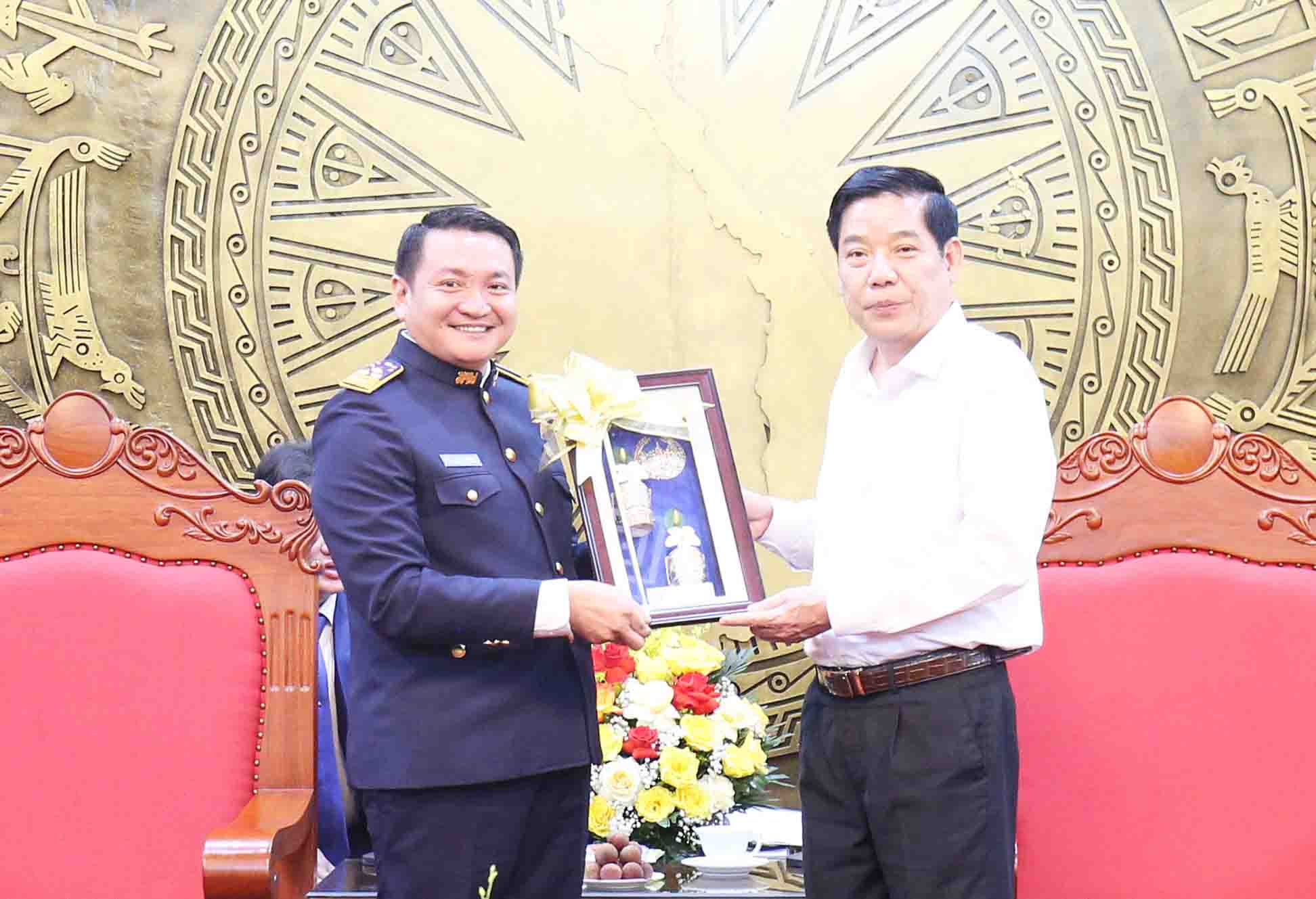 Kham Phay 씨 - Xay Nha Xuc 씨가 Nguyen Van Gau 박닌성 당 서기에게 라오스의 국화 상징인 참파 꽃 자수 그림을 선물하고 있습니다. 사진: Nguyen Nhan