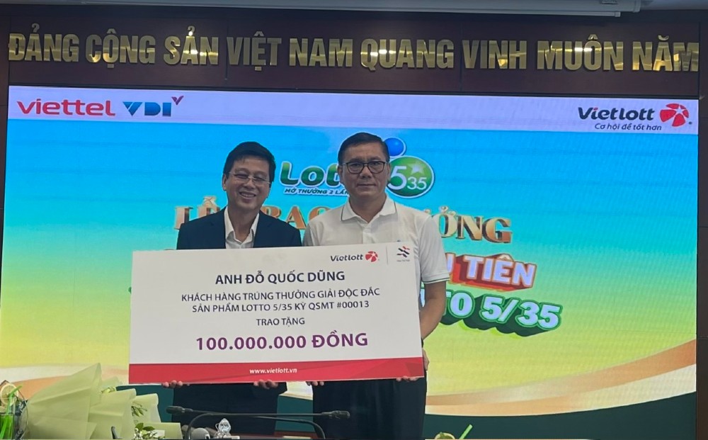 Anh Do Quoc Dung trao 100 trieu dong de xay dung nha tinh nghia/dai doan ket. Anh: Vietlott