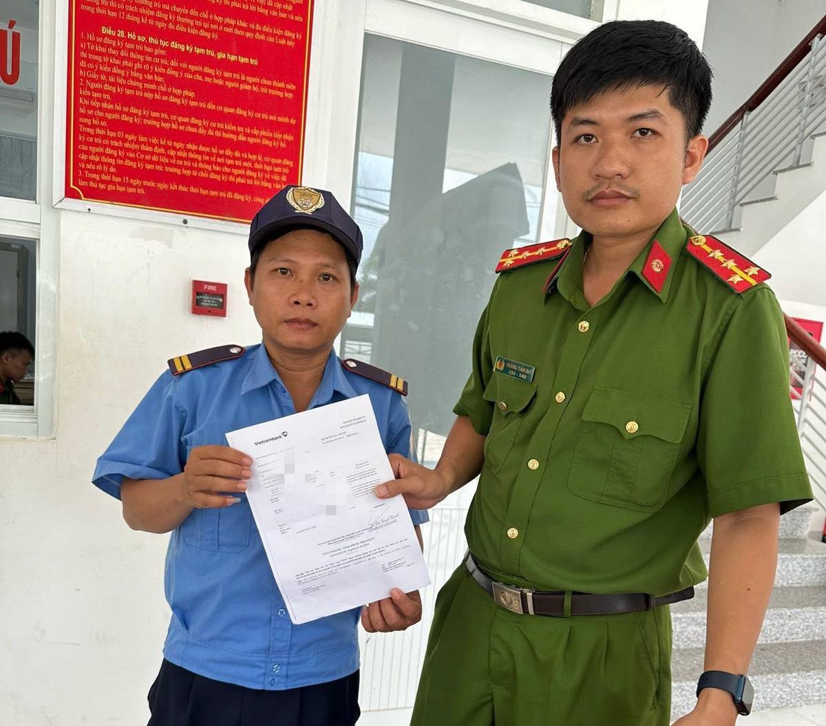 Nhan vien bao ve hoan tat viec tra lai tien chuyen khoan nham sau khi duoc cong an xa huong dan. Anh: Cong an
