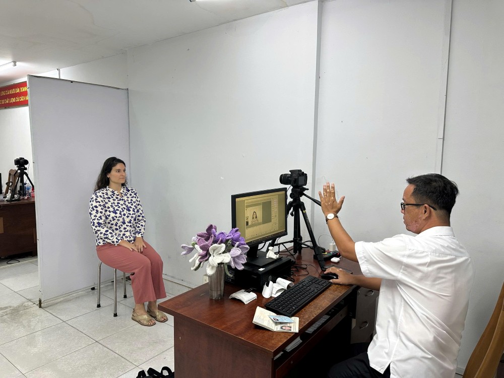 Chup anh cho nguoi nuoc ngoai de lam thu tuc. Anh: Anh Tu