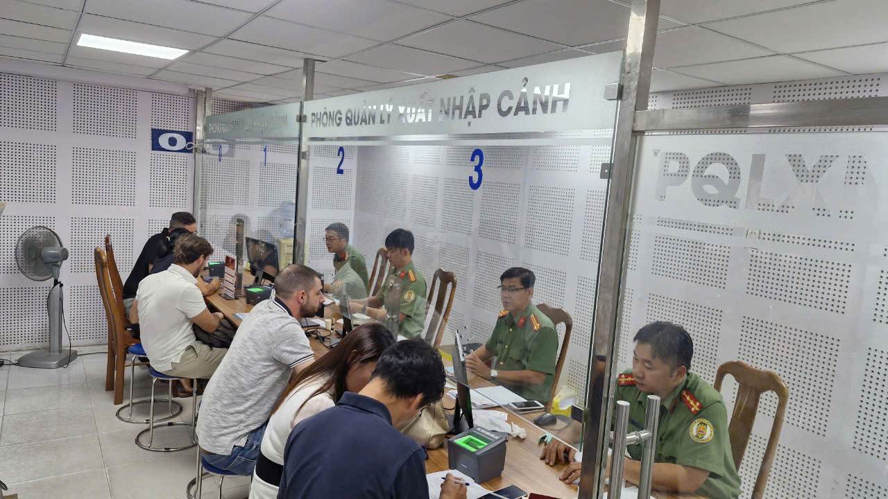 Dong nguoi nuoc ngoai den lam dinh danh dien tu tai Phong Quan ly Xuat nhap canh (PA08, Cong an TPHCM). Anh: Anh Tu