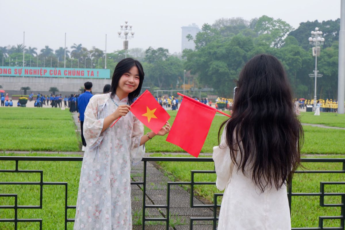 Young people dressed in ao dai and traditional costumes to take photos in front of Ba Dinh Square to celebrate the 30th anniversary of the 4th anniversary. Photo: Mai Phuong