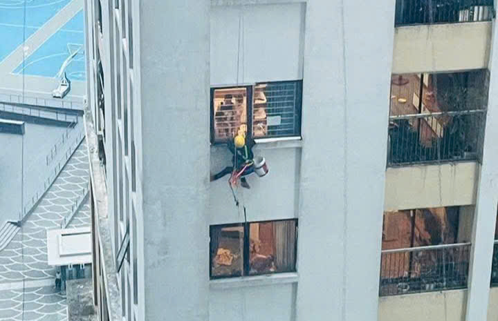 7月19日午後、竜巻の嵐の中で、Vinaconex 2マンションの窓に忍び込んだ男性製図工。写真:イエン・ミー