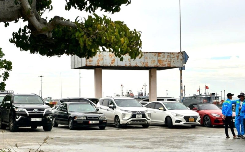 Vehicles are parked in the wharf, waiting to board the ferry on the afternoon of July 19. Photo: Thanh An