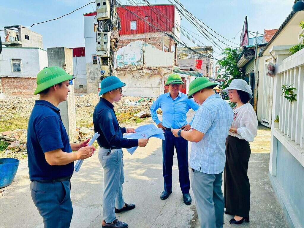 지방 지도자들이 프로젝트 시행 지역 주민들의 의견을 경청하면서 현장을 조사하고 있습니다. 사진: 뜨민 동