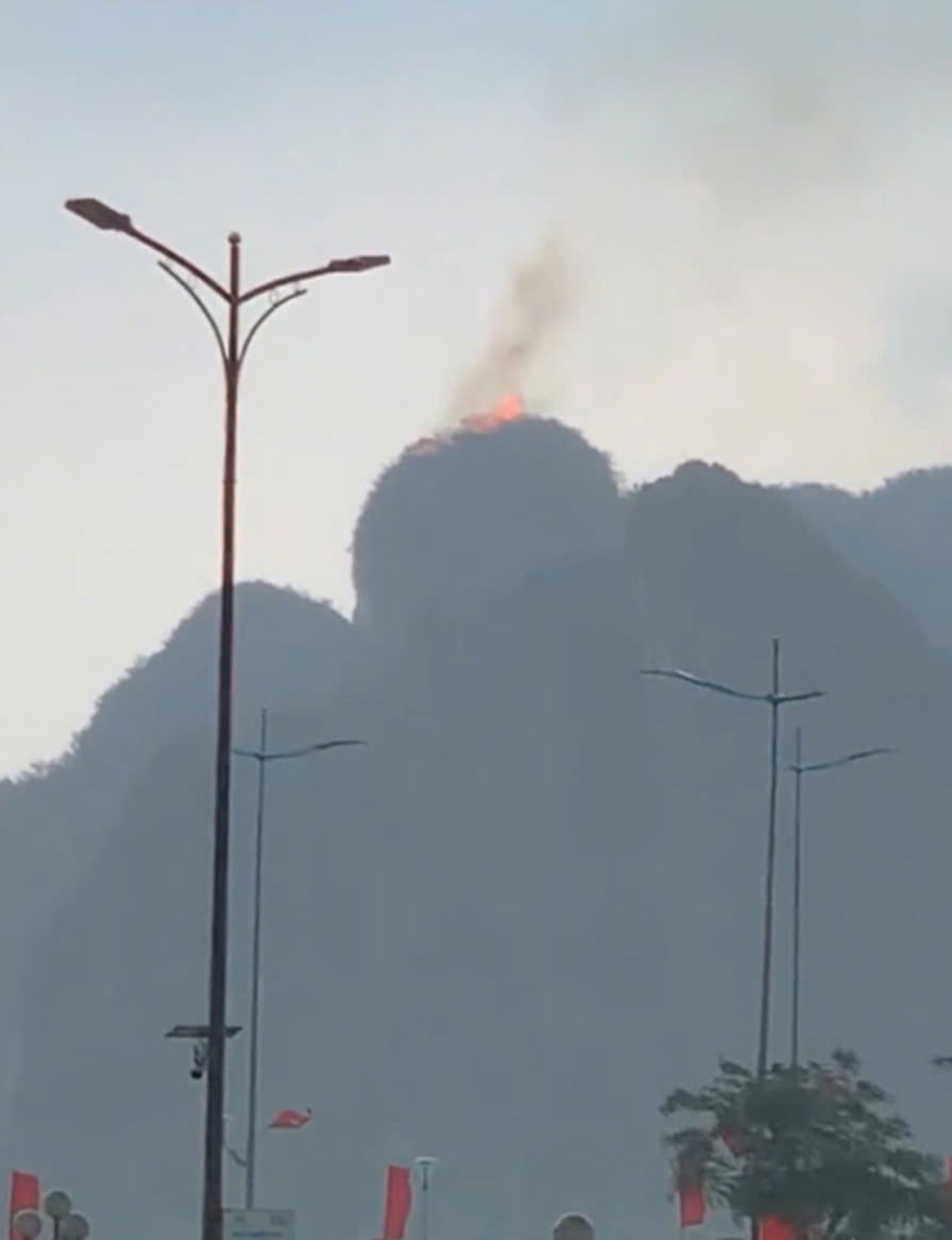 Ha Long湾岸の山頂で石灰岩が粉塵を燃やしています。ビデオクリップから切り取った写真。