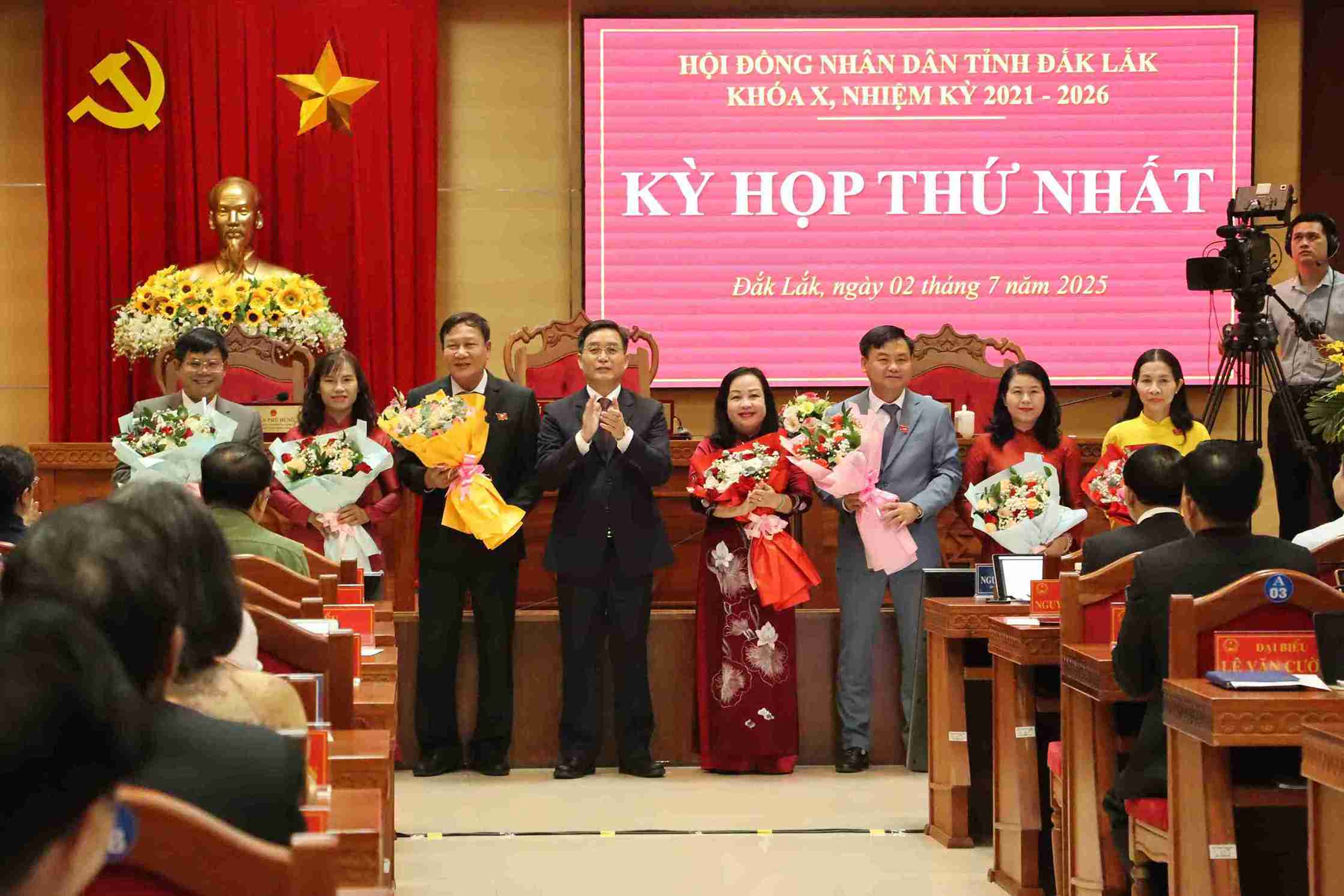 Les dirigeants du Comite provincial du Parti de Dak Lak offrent des fleurs pour feliciter les presents lors de la session du Conseil populaire provincial du Xe mandat 2021-2026. Photo : Bao Trung