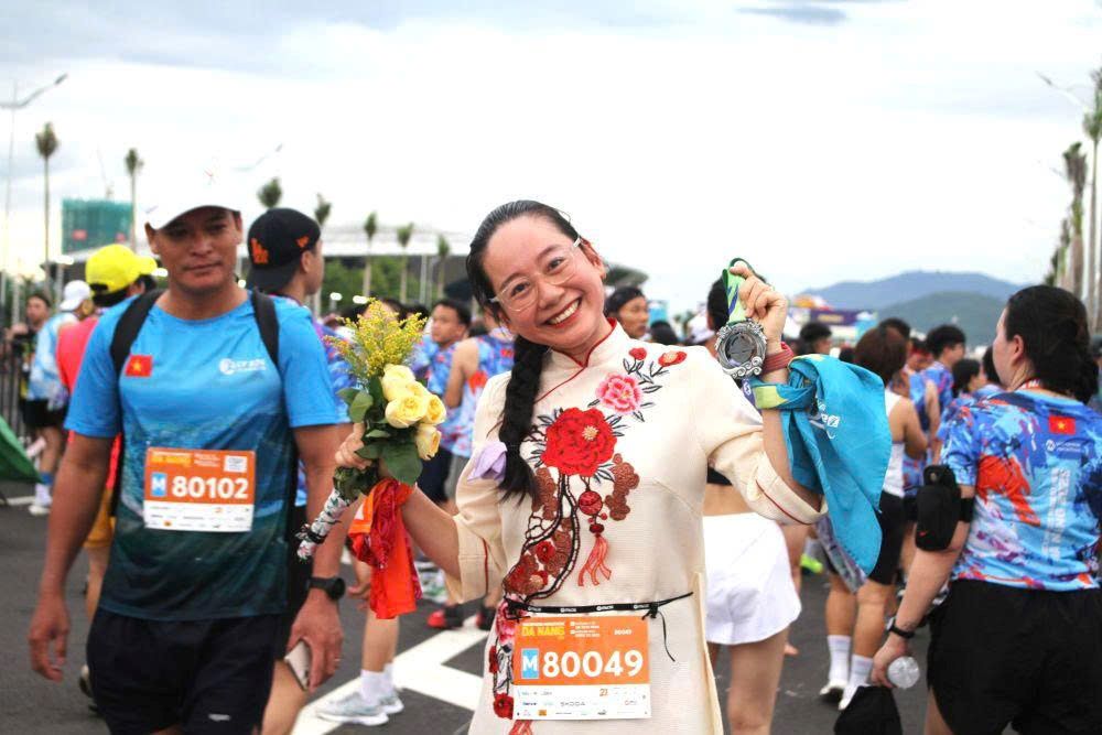 VnExpress Marathon Da Nang 2025에 참가하는 아오자이를 입은 운동선수. 사진: Thanh Huyen