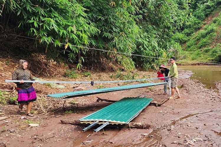 People in Tang Phon village, Nam Ke commune, Dien Bien province transported materials about 2km across the stream to the village. Photo: Duc Thiep