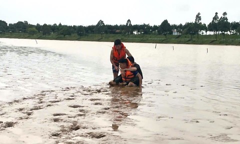 Cảnh sát cứu hộ cứu nạn đưa hai anh em ruột bị đuối nước lên bờ an toàn. Ảnh: Công an cung cấp 
