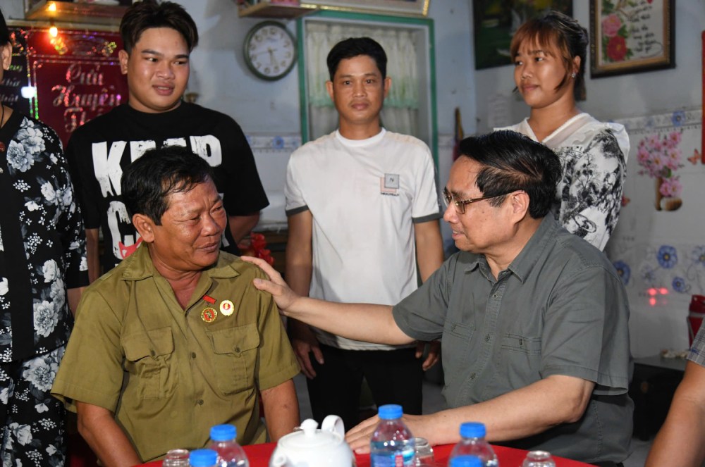 Pham Minh Chinh 총리가 Chau Doc 구에 거주하는 Huynh Van Anh 씨(1967년생 부상병 81%)에게 안부를 묻고 격려하고 있습니다. 사진: Phuong Vu