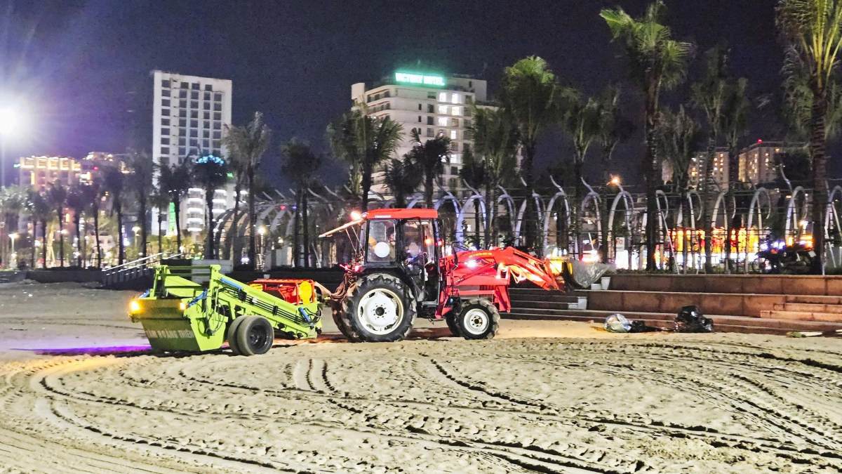 Garbage trucks clean up Vung Tau beach at night. Photo: Nam Nguyen