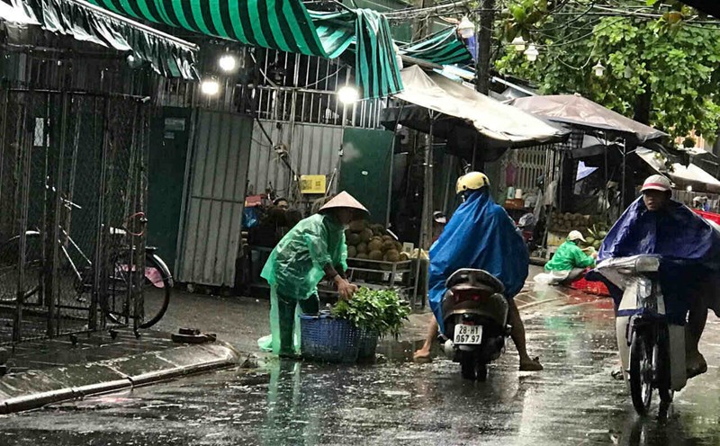 Despite heavy rain due to the impact of storm No. 3, traders at Nghia Phuong market, Hoa Binh ward, Phu Tho province still cling to the market to make a living, protecting their goods from the pouring rain and wind. Photo: Yen San