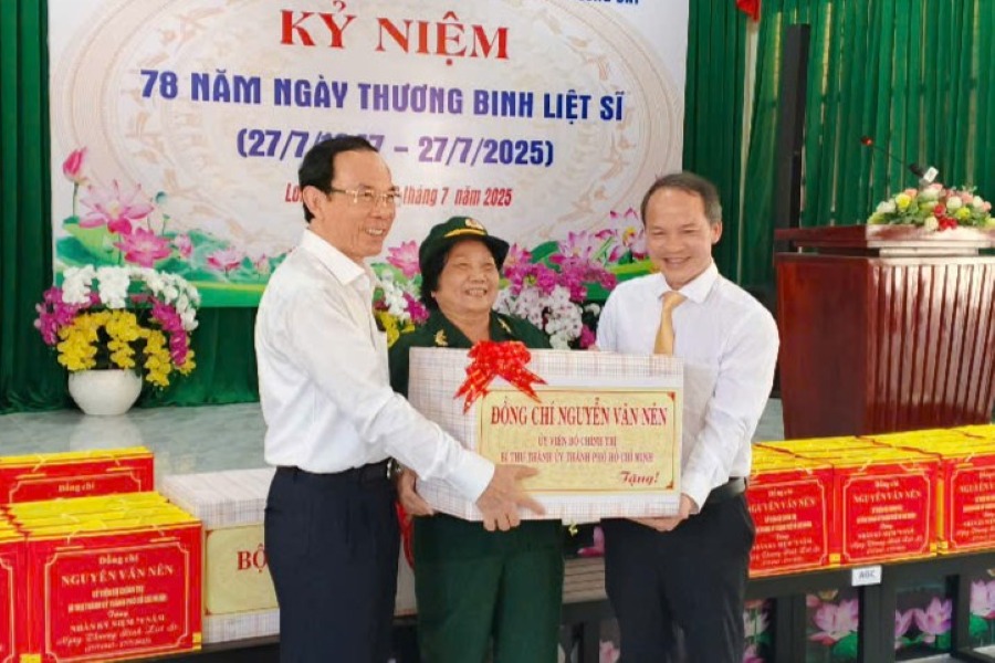 호치민시 당위원회 서기인 응우옌 반 넨(Nguyen Van Nen) 정치국 위원이 롱하이(Long Hai) 면의 부상병 부상병 공로자에게 선물을 전달하고 있습니다. 사진: 탄 안(Thanh An)