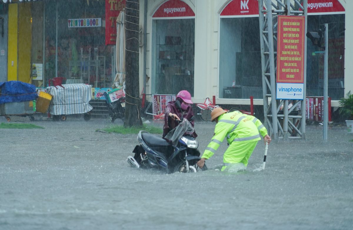 Ho tro cac phuong tien xe may bi chet may khi di qua doan duong ngap. Anh: Cong an Thanh Hoa