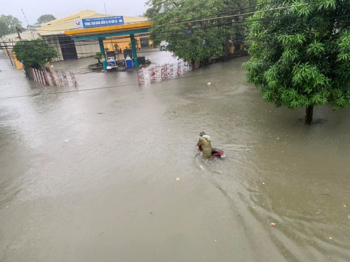 長期にわたる雨により、タインホアの多くの道路が深く浸水し、住民は浸水を乗り越えるのに苦労し、移動が困難になっています。写真:Tran Lam