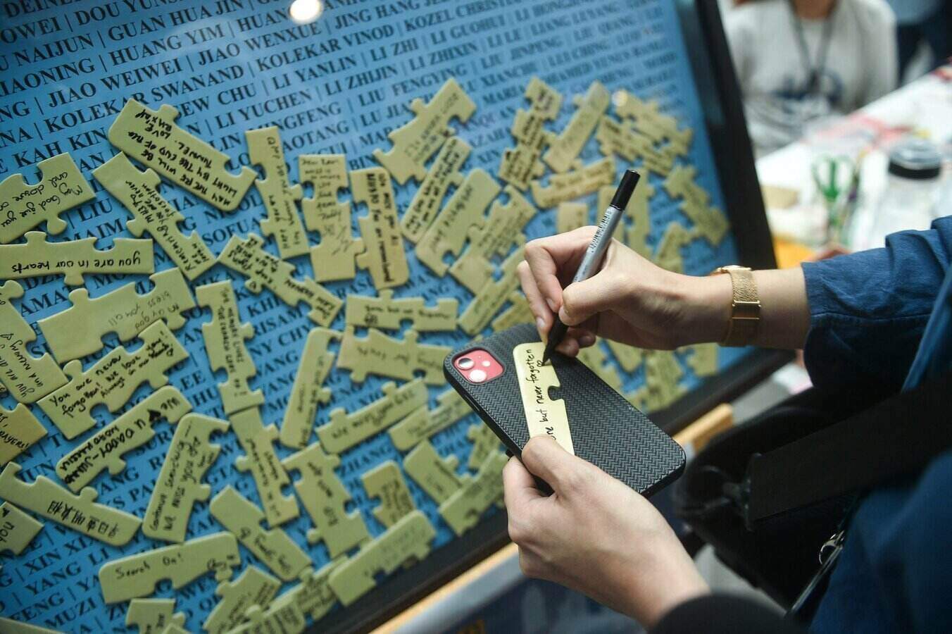 A woman wrote a message at an event in March 2024 to celebrate the 10th anniversary of the disappearance of MH370. Photo: AFP