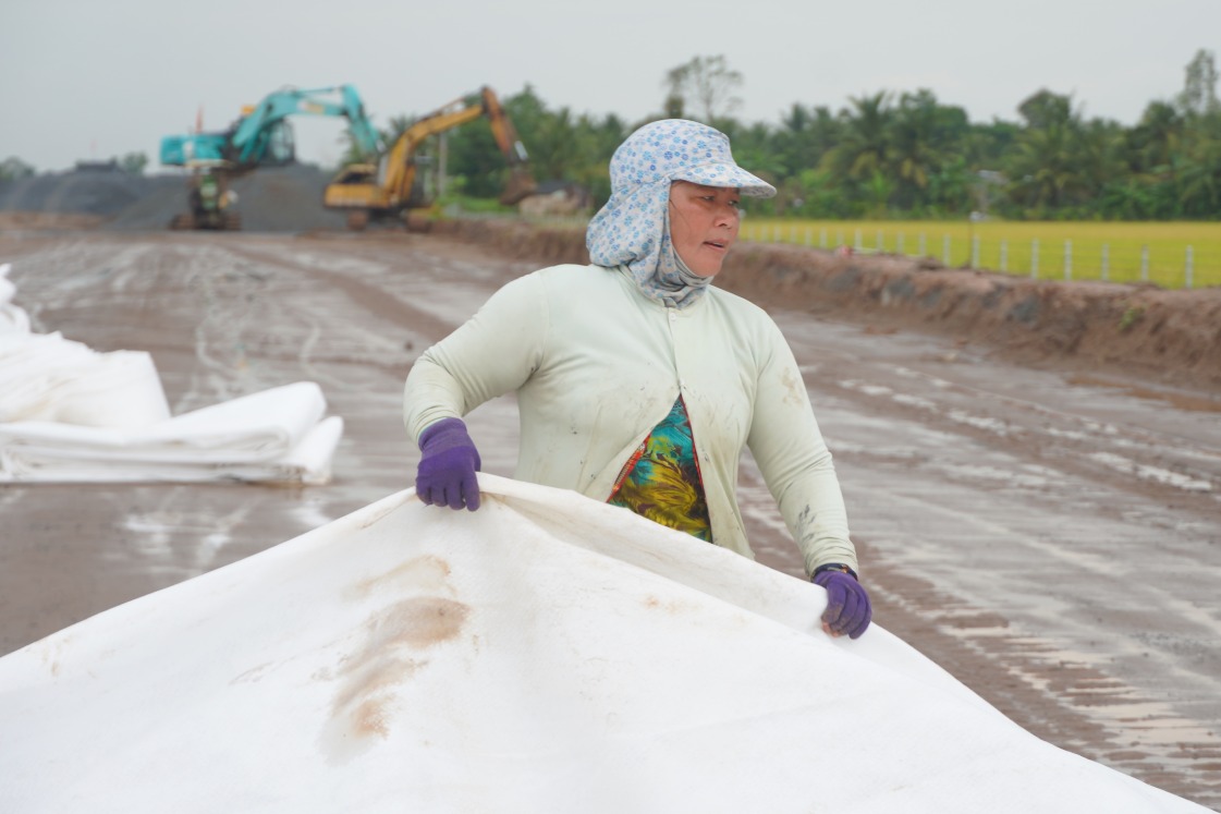 Ba Huynh Ngoc Mai cung cac cong nhan khac thi cong phan trai vai dia ky thuat. Anh: Ta Quang