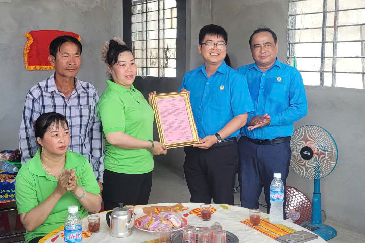 응우옌티년(Nguyen Thi Nhan) 조합원이 결정서를 받아 노동조합의 따뜻한 보금자리를 전달하고 있습니다. 사진: 떠이닌(Tay Ninh)성 노동총연맹
